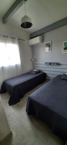 a bedroom with two beds and a window at T3 dans villa proche Calvi mer piscine in Montegrosso