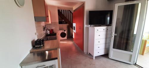 a kitchen with a sink and a tv in a room at T3 dans villa proche Calvi mer piscine in Montegrosso