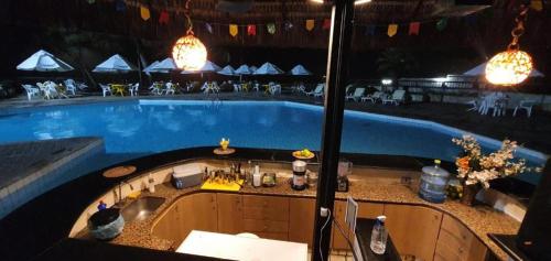 a large swimming pool with a bar in front of it at Aconchegante Flat na Orla in Recife