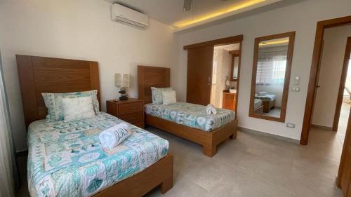a bedroom with two beds and a mirror at Nicole Residence in Las Terrenas