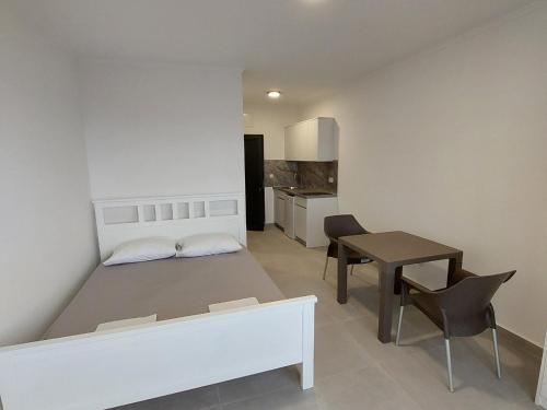 a bedroom with a bed and a table in a room at Top Apartments in Dobra Voda