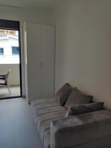 a living room with a couch and a sliding glass door at Top Apartments in Dobra Voda