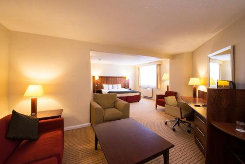 a hotel room with a bed and a living room at Holiday Inn Northampton by IHG in Northampton