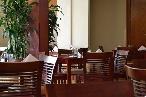 an empty restaurant with wooden tables and chairs at Holiday Inn Northampton by IHG in Northampton