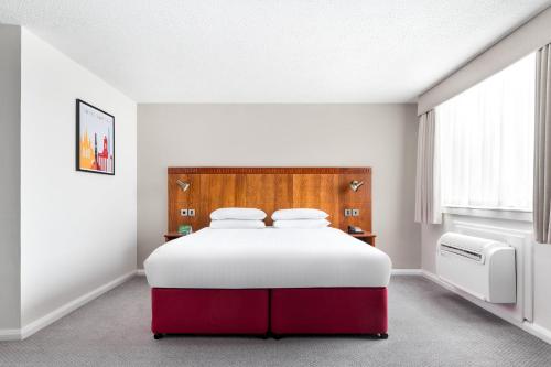 a bedroom with a large white and red bed at Holiday Inn Northampton by IHG in Northampton