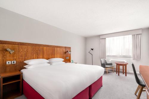 a hotel room with a large bed and a table at Holiday Inn Northampton by IHG in Northampton