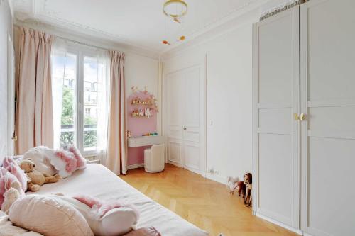 une chambre avec un lit avec des animaux en peluche dessus dans l'établissement Elegant Apt 2BDR Arc de Triomphe Champs-Élysées, à Paris