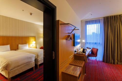 a hotel room with a bed and a desk and a bedroom at Park Inn by Radisson Aberdeen in Aberdeen