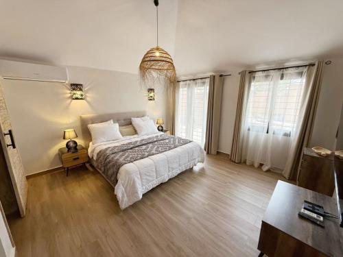 a bedroom with a large bed and two windows at Agence Adjana Resort - Résidence du Port 3 in Sali Tapé