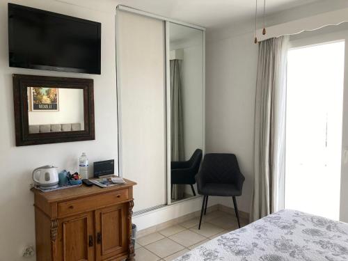 a bedroom with a bed and a mirror and a chair at chambre d'hôtes Villa Côte Vermeille in Argelès-sur-Mer