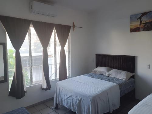 un dormitorio con una cama y una ventana grande en Centrico, seguro, buen precio, Timon, en Manzanillo
