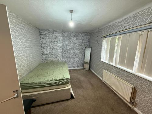 a small room with a bed and a window at Near Hylands hotel family room in Nottingham