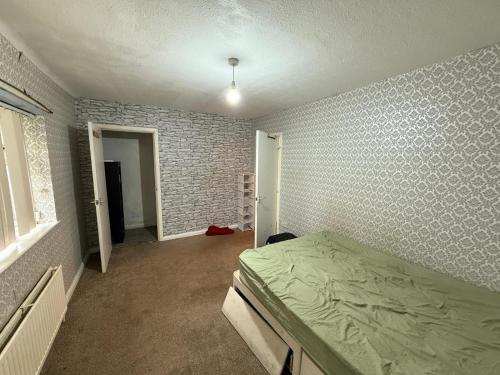 a bedroom with a bed and a brick wall at Near Hylands hotel family room in Nottingham