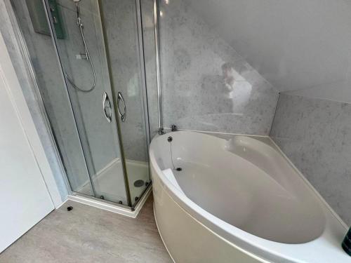 a bathroom with a shower and a white bath tub at The Hebridean - Rooms & Apartments in Broadford