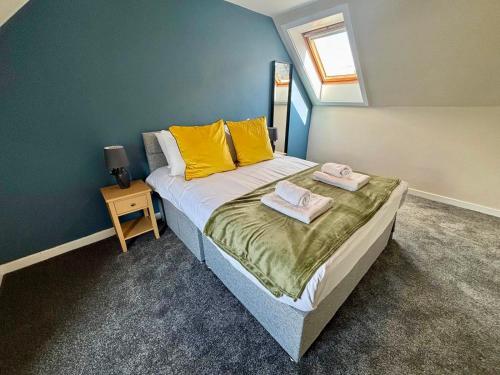 a bedroom with a bed with yellow pillows and a window at The Hebridean - Rooms & Apartments in Broadford