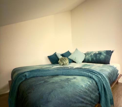 a bedroom with a bed with blue sheets and pillows at Le Repère du Mont-Saint-Anne in Beaupré
