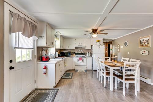 a kitchen with white cabinets and a table and chairs at Steps to Crystal Lake Spacious Retreat with Views in Barton