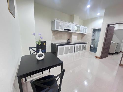 a kitchen with a black table and a black chair at Paradise Hotel & Apartment in Vientiane