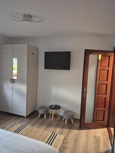 a bedroom with a bed and a tv on the wall at La Miruna in Comăneşti