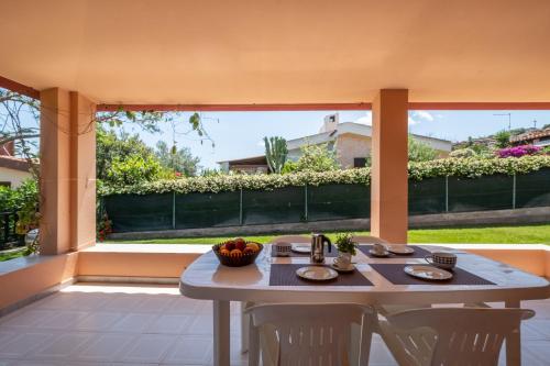 a table and chairs sitting on a patio at 5 min dal mare - Ampia villa con Terrazza e Aria Condizionata in Costa Rei