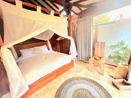 1 dormitorio con cama con dosel y alfombra en BaraJade Villa, en Uluwatu