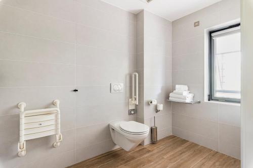 a white bathroom with a toilet and a window at Crowne Plaza Lyon - Cité Internationale in Lyon