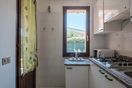 a small kitchen with a sink and a window at 5 min dal mare - Ampia villa con Terrazza e Aria Condizionata in Costa Rei