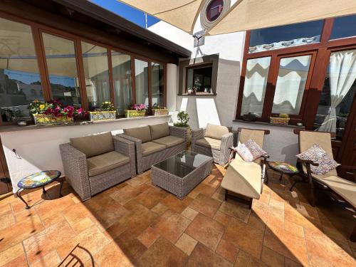 an outdoor patio with couches and tables and windows at Diana Brown B&B Affittacamere in Lipari