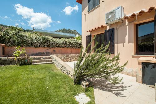 a house with a yard with a grass at 5 min dal mare - Ampia villa con Terrazza e Aria Condizionata in Costa Rei