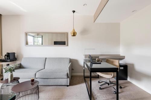 a living room with a couch and a desk at Crowne Plaza Lyon - Cité Internationale in Lyon