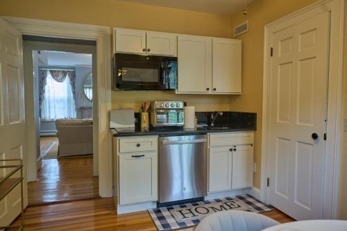 a kitchen with white cabinets and a microwave at The Underwood-Hale House in Providence