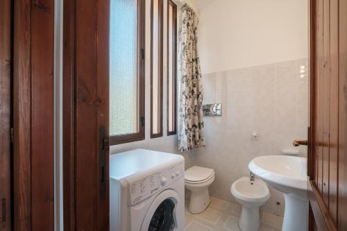 a bathroom with a washing machine and a sink at 5 min dal mare - Ampia villa con Terrazza e Aria Condizionata in Costa Rei