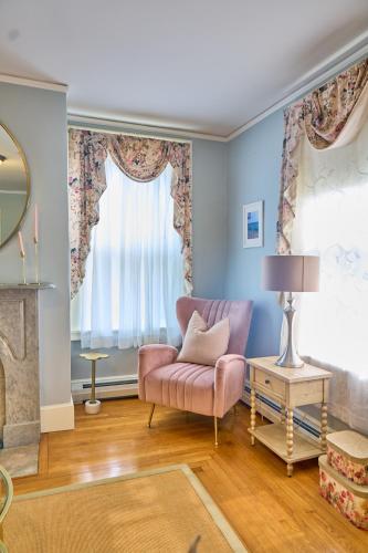 a living room with a pink chair and a window at The Underwood-Hale House in Providence