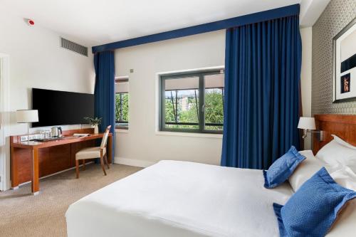 a hotel room with a bed and a desk at Crowne Plaza Lyon - Cité Internationale in Lyon