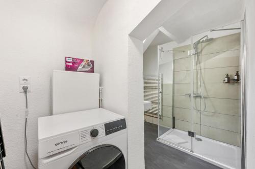 a washing machine in a bathroom with a shower at Sali Homes - Schwäbisch Hall - Altstadt GG 95 in Schwäbisch Hall