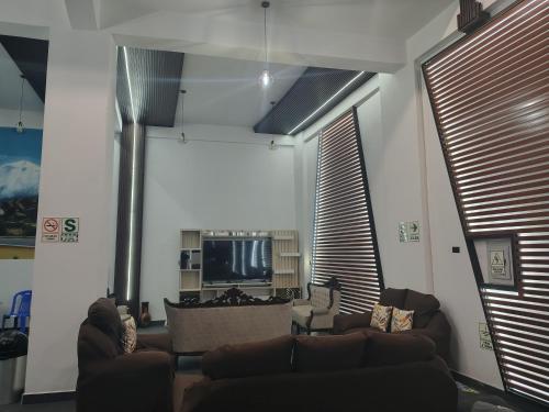 a living room with two couches and a television at Hotel El Castor in Huaraz