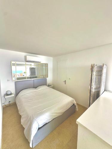 une chambre blanche avec un lit et une fenêtre dans l'établissement T2 - Grande terrasse, Vue mer, Piscine, à Bandol