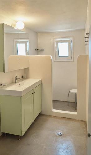 a bathroom with a sink and a mirror at Maira Arch House in Potamós