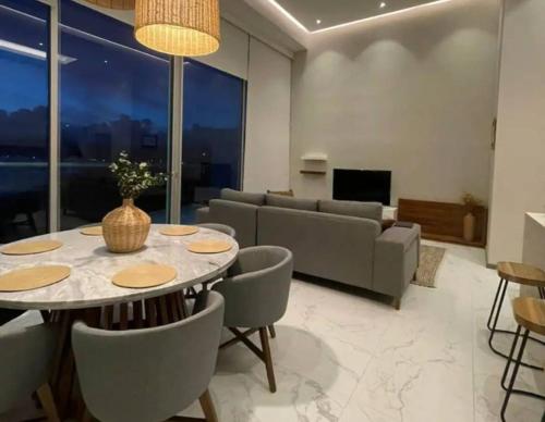 een woonkamer met een tafel, stoelen en een bank bij Nuevo Vallarta Beachfront Condo! in Bucerías