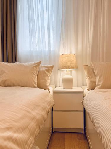 a bedroom with two beds and a lamp on a night stand at Luxury apartment L with jacuzzi in Split