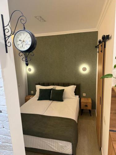 a bedroom with a bed with a clock on the wall at Loft Evn in Yerevan