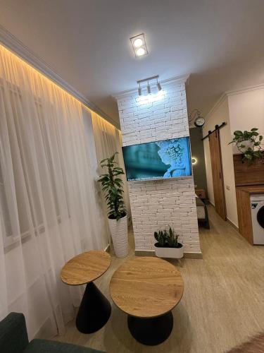 a living room with two tables and a tv at Loft Evn in Yerevan