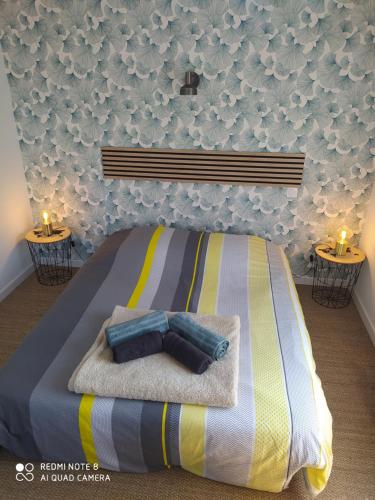 - une chambre avec un lit, des serviettes et 2 bougies dans l'établissement appartement dans maison de caractère en pierre, à Saint-Malo