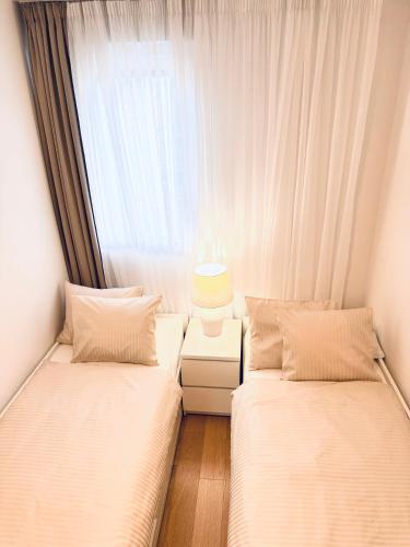 two beds in a room with a window at Luxury apartment L with jacuzzi in Split