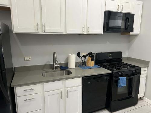 a kitchen with a sink and a stove and a microwave at South Loop 2 Bedroom Apt in Chicago