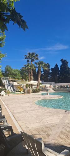- une piscine avec des chaises, des arbres et de l'eau dans l'établissement sept font, à Agde