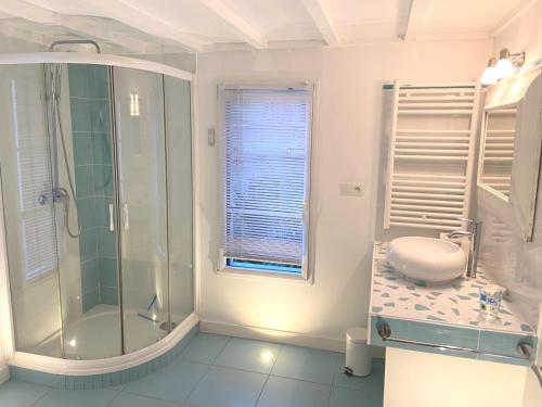 a white bathroom with a shower and a sink at Villa Ker Zen 300m de la plage in La Baule