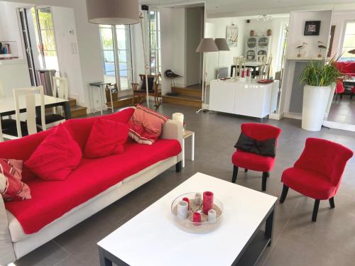 a living room with a red couch and red chairs at Villa Ker Zen 300m de la plage in La Baule