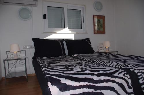 a black and white bed in a room with a window at Apartments Lux in Makarska