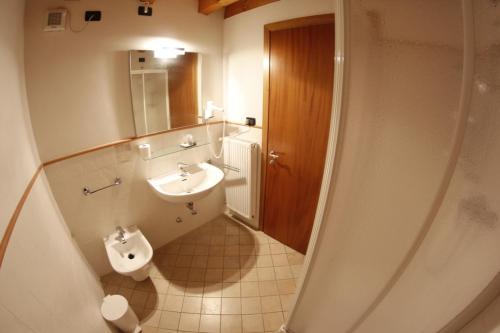 een badkamer met een wastafel, een toilet en een spiegel bij Agriturismo Mazzeracca in Bassano del Grappa